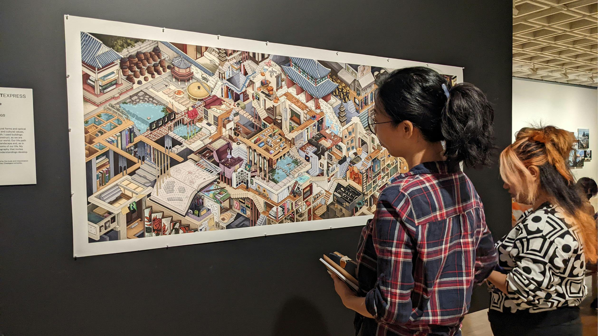 Student looking at 3D illustrated artwork hung on a wall